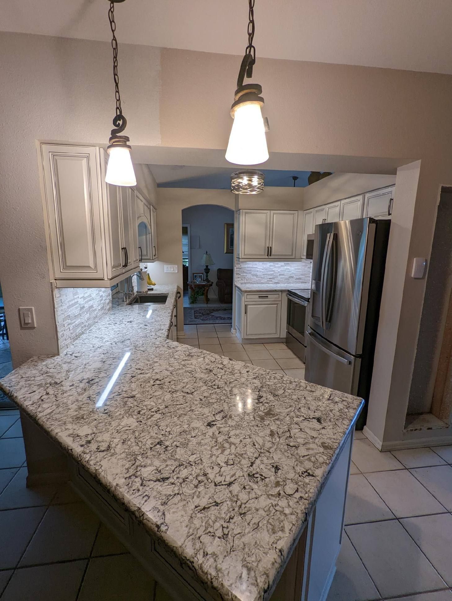 Kitchen with light gray cabinets, white countertops, and stainless steel appliances.