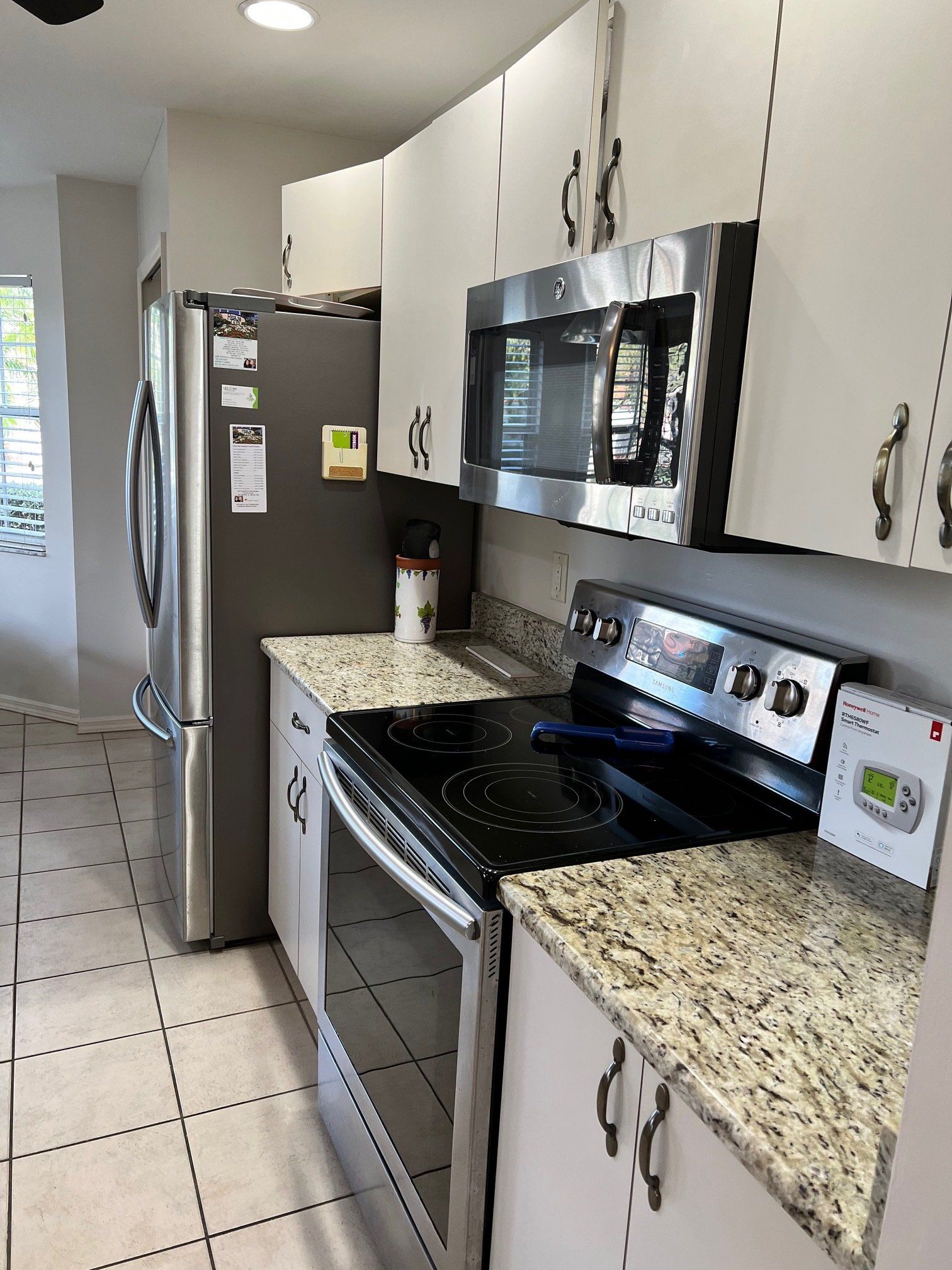 Kitchen with stainless steel appliances, white cabinets, and granite countertops.