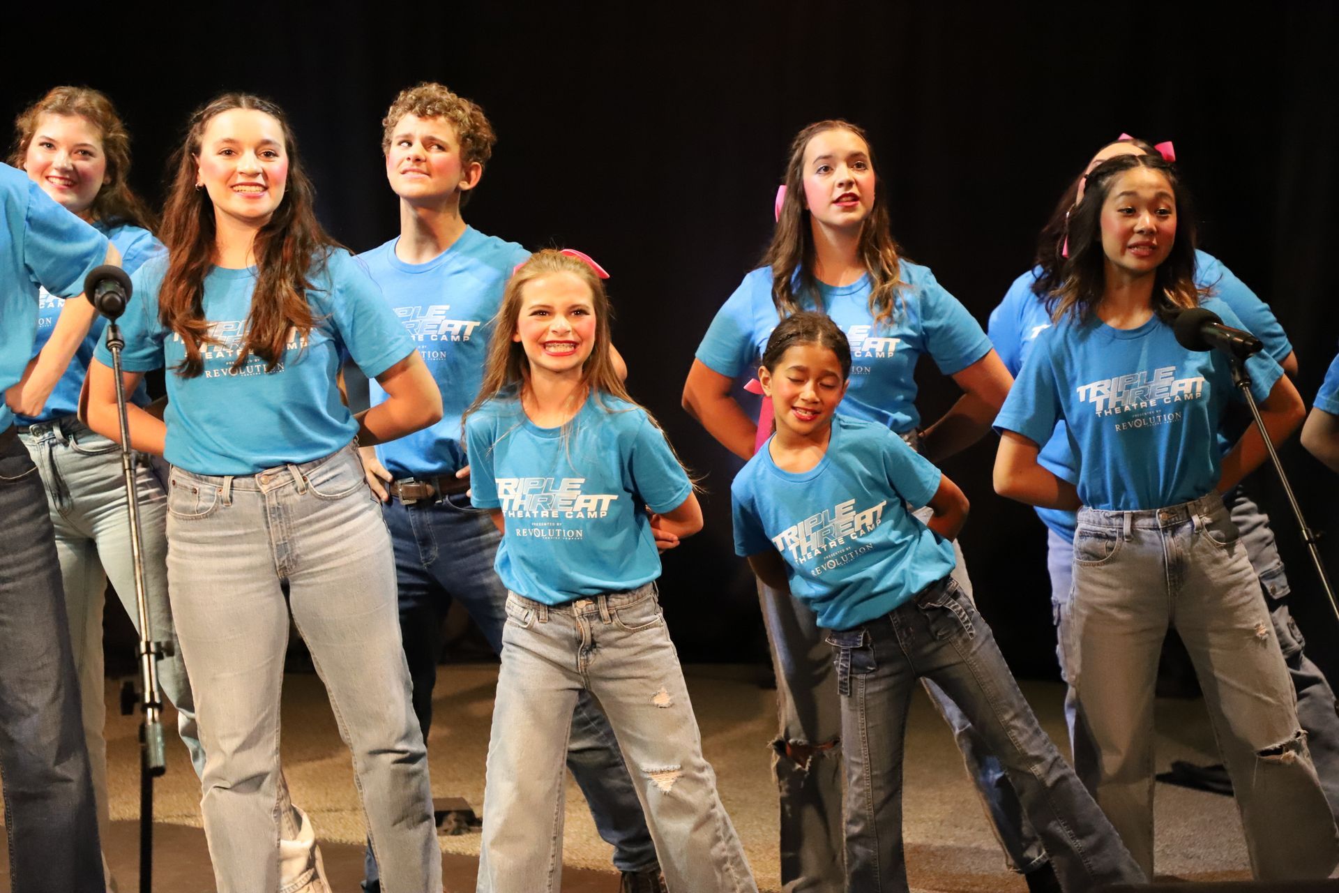 A group of young people are standing next to each other on a stage.