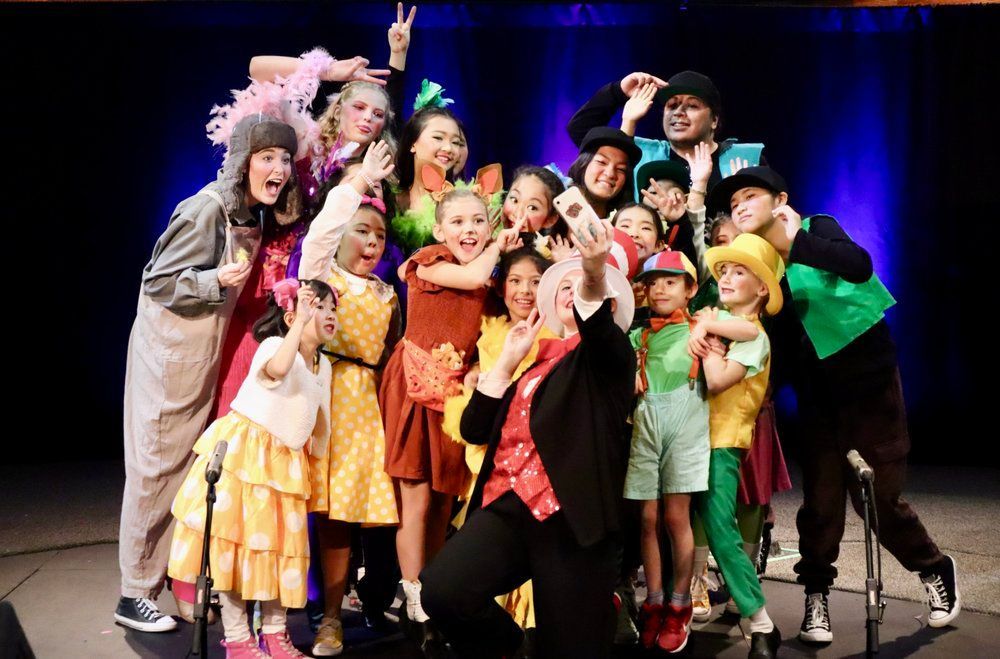 A group of children are posing for a picture on a stage.