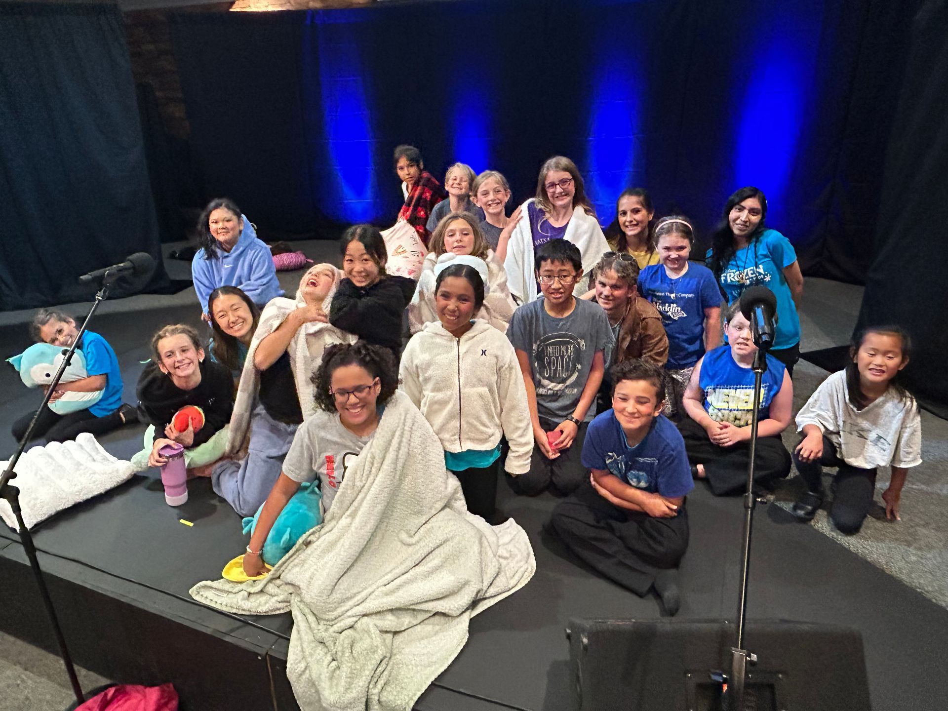 A group of children are posing for a picture on a stage.