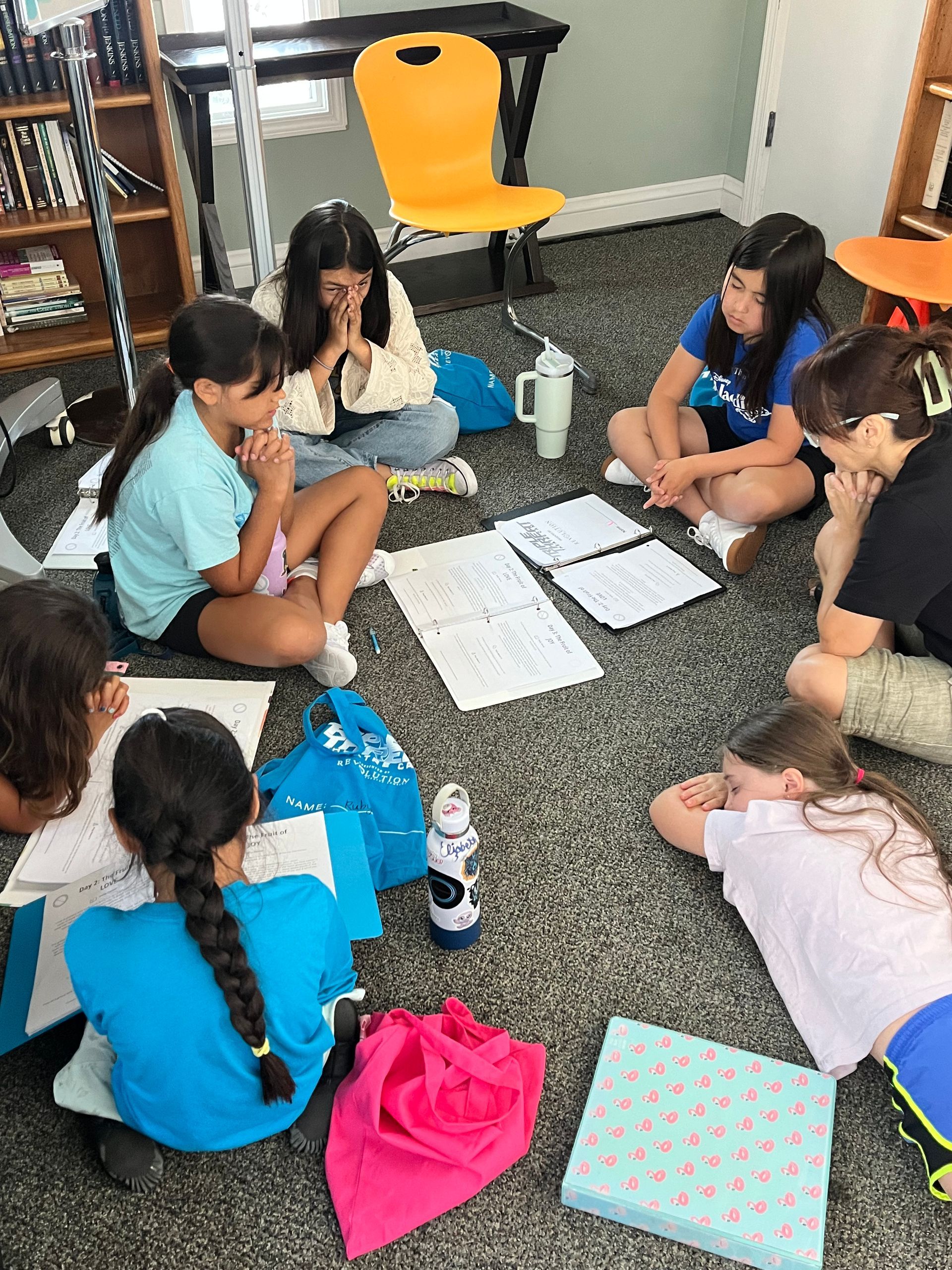 A group of children are sitting in a circle on the floor.