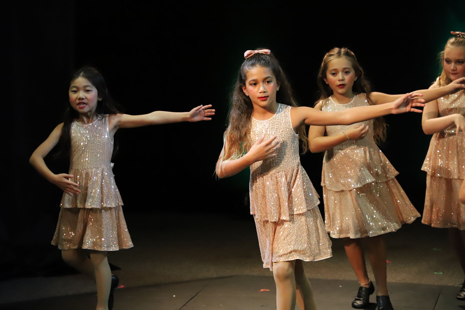 A group of young girls are dancing on a stage.