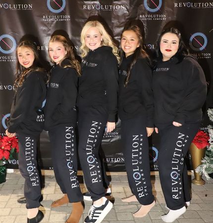A group of girls wearing revolution sweatpants are posing for a picture