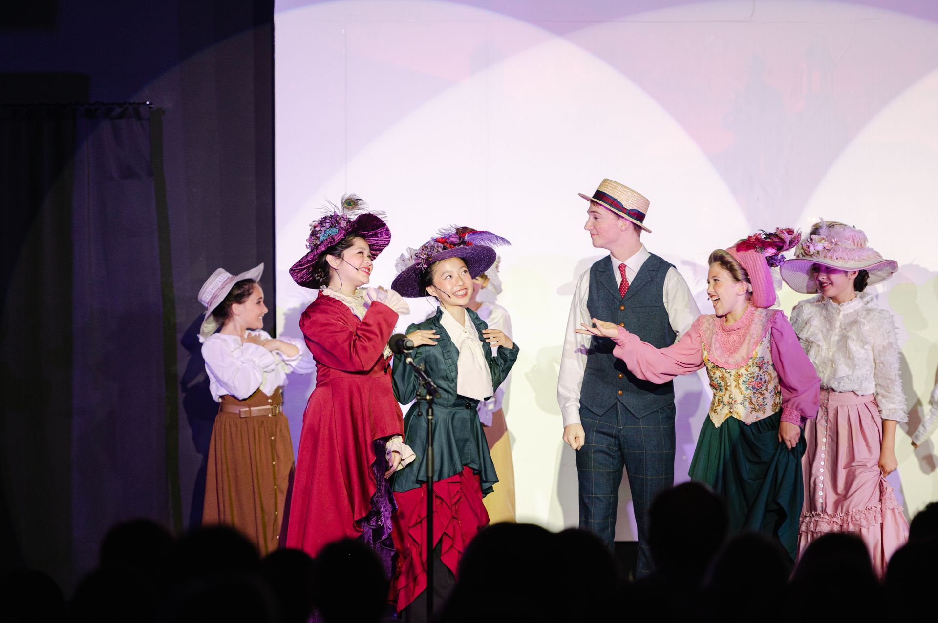 Seven performers in period costumes onstage standing in a line and facing each other from The Music Man