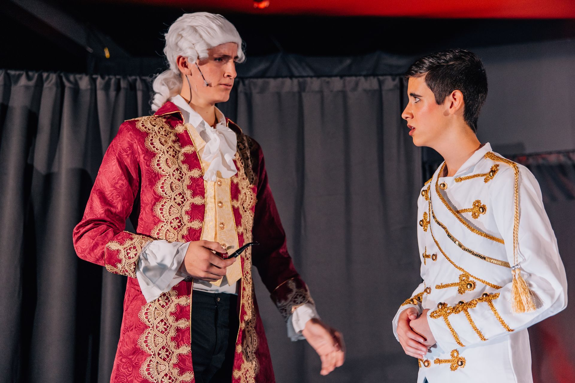Two actors in ornate period costumes face each other on a stage for the  Little Mermaid stage production.