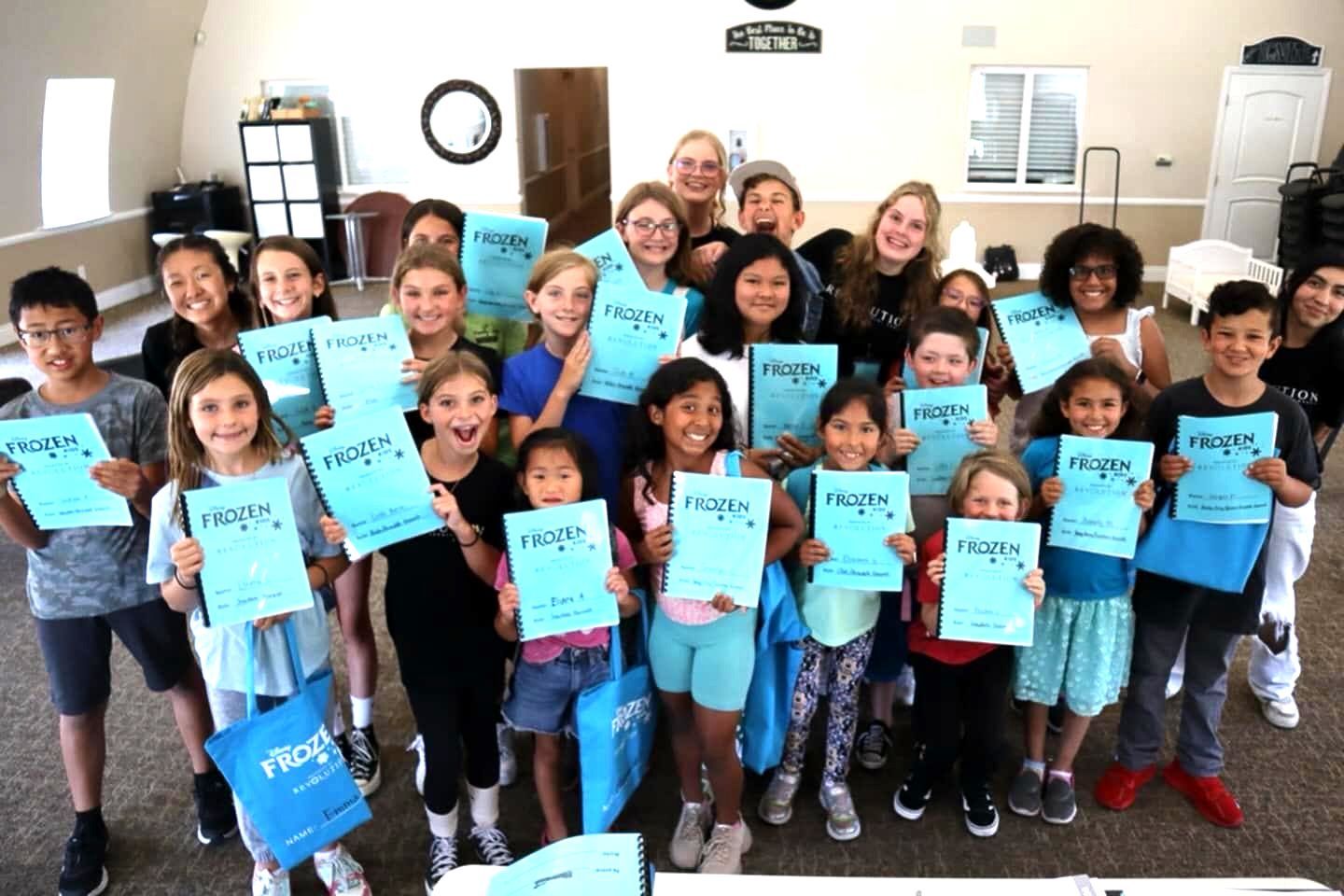 A group of children are posing for a picture while holding up papers.