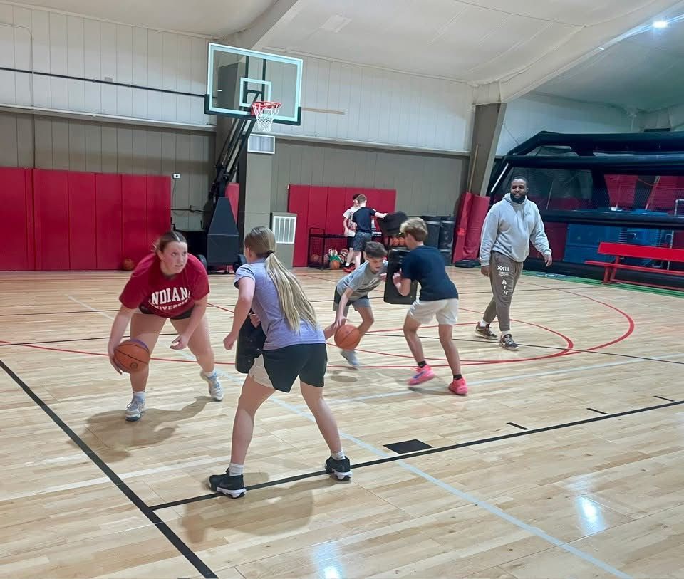 A group of people are playing basketball on a court.