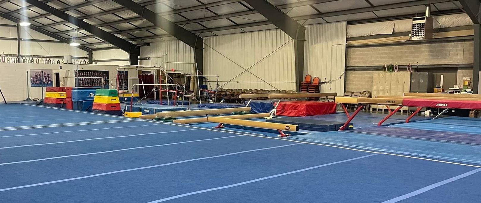 A gym with a blue floor and a lot of equipment.