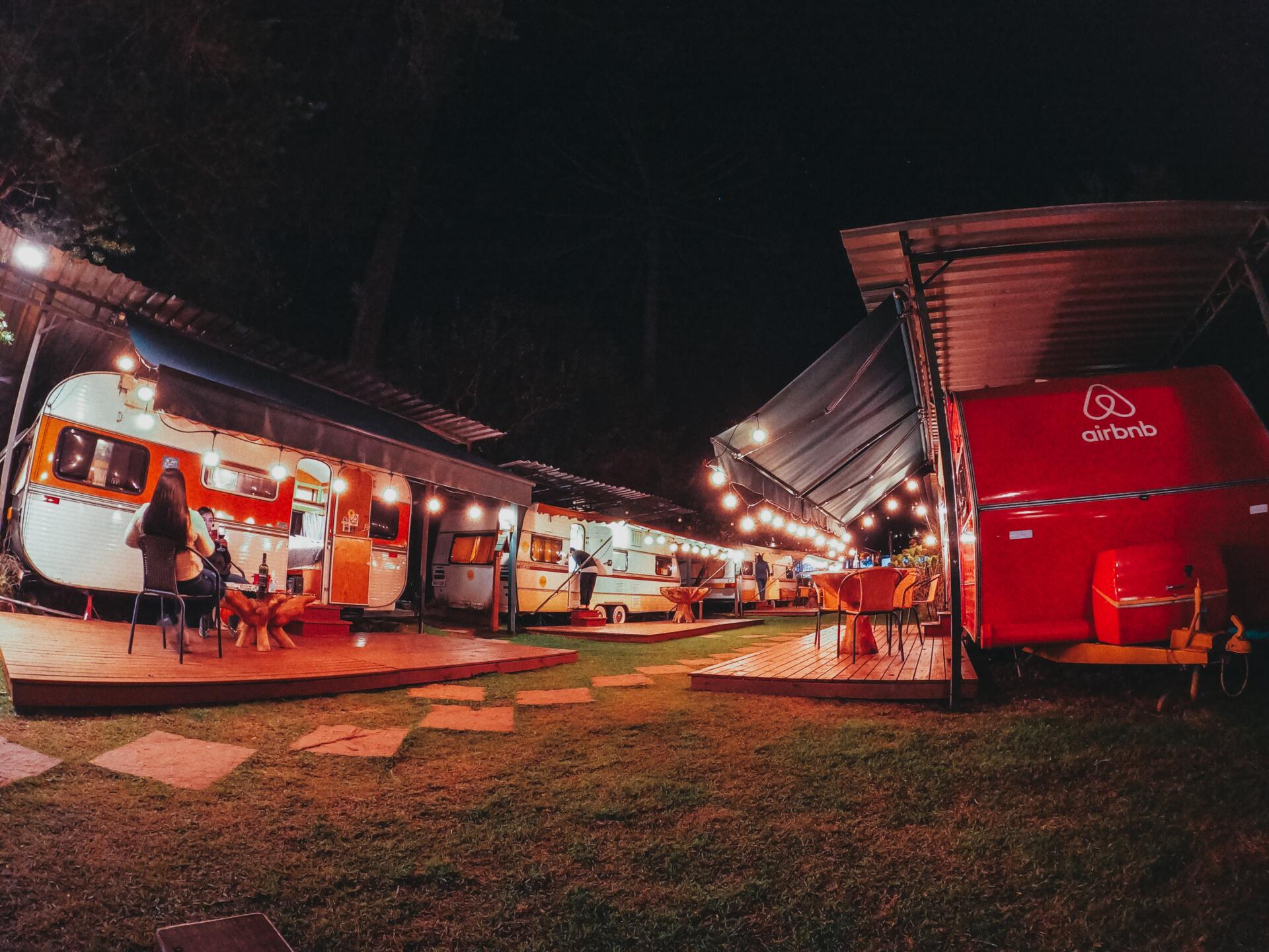 tourists sitting near RV at night