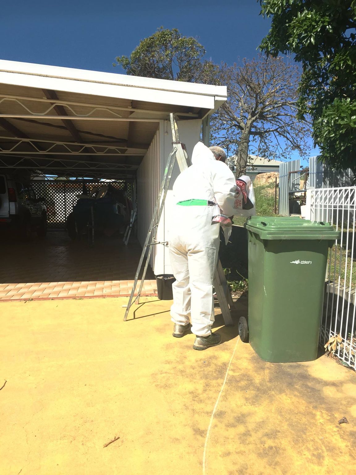 Construction site with a contained area wrapped in clear plastic and hazard tape.