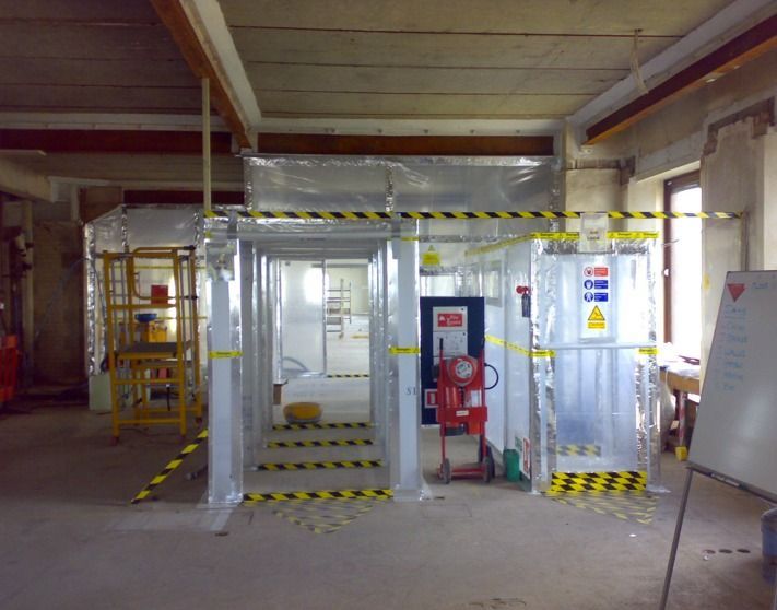 Backyard with metal fence and gate, building under construction.