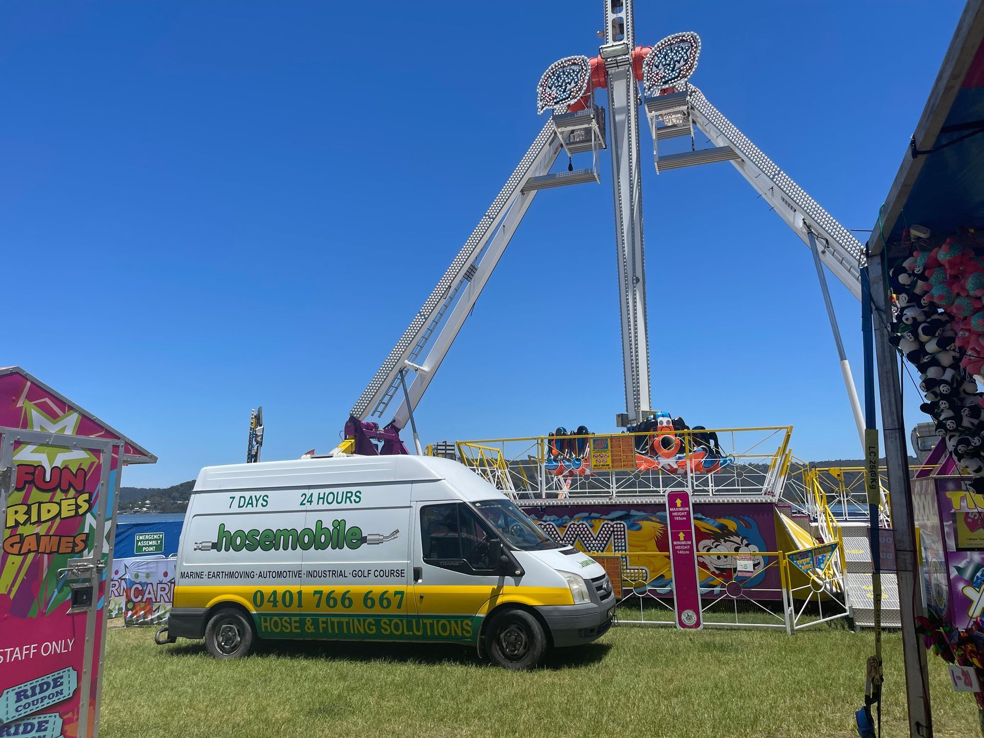 A white van is parked in front of a carnival ride — Hosemobile In Kariong, NSW