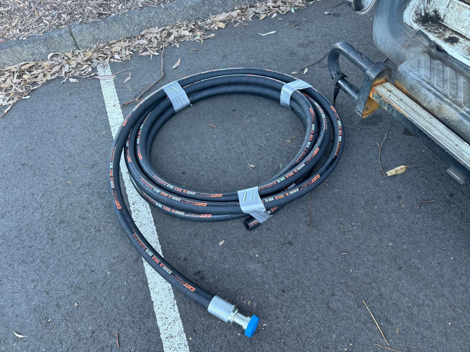 A hose is sitting on the ground next to a car. — Hosemobile In Kariong, NSW