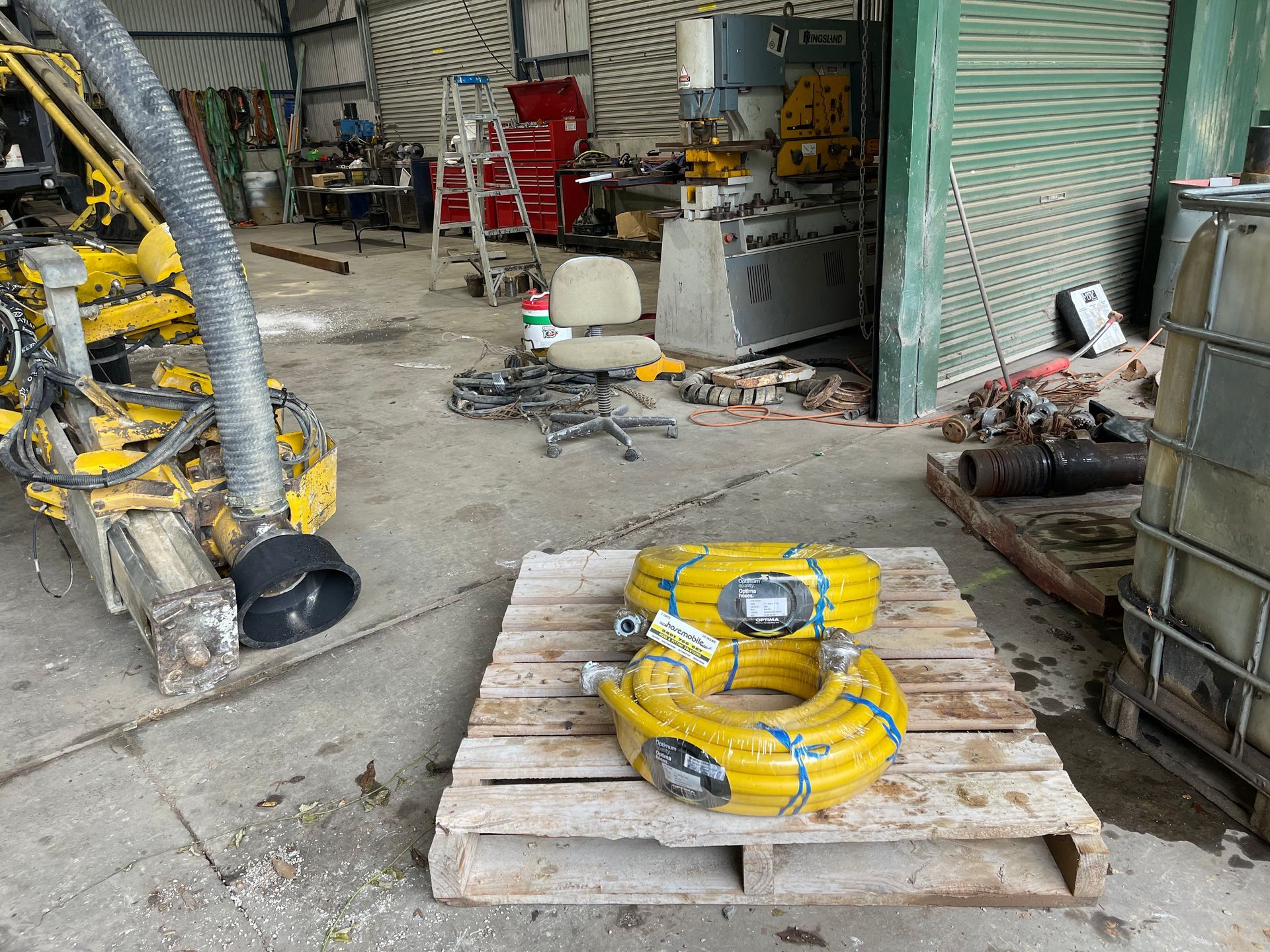 A wooden pallet with yellow hose on it in a garage. — Hosemobile in Gosford, NSW