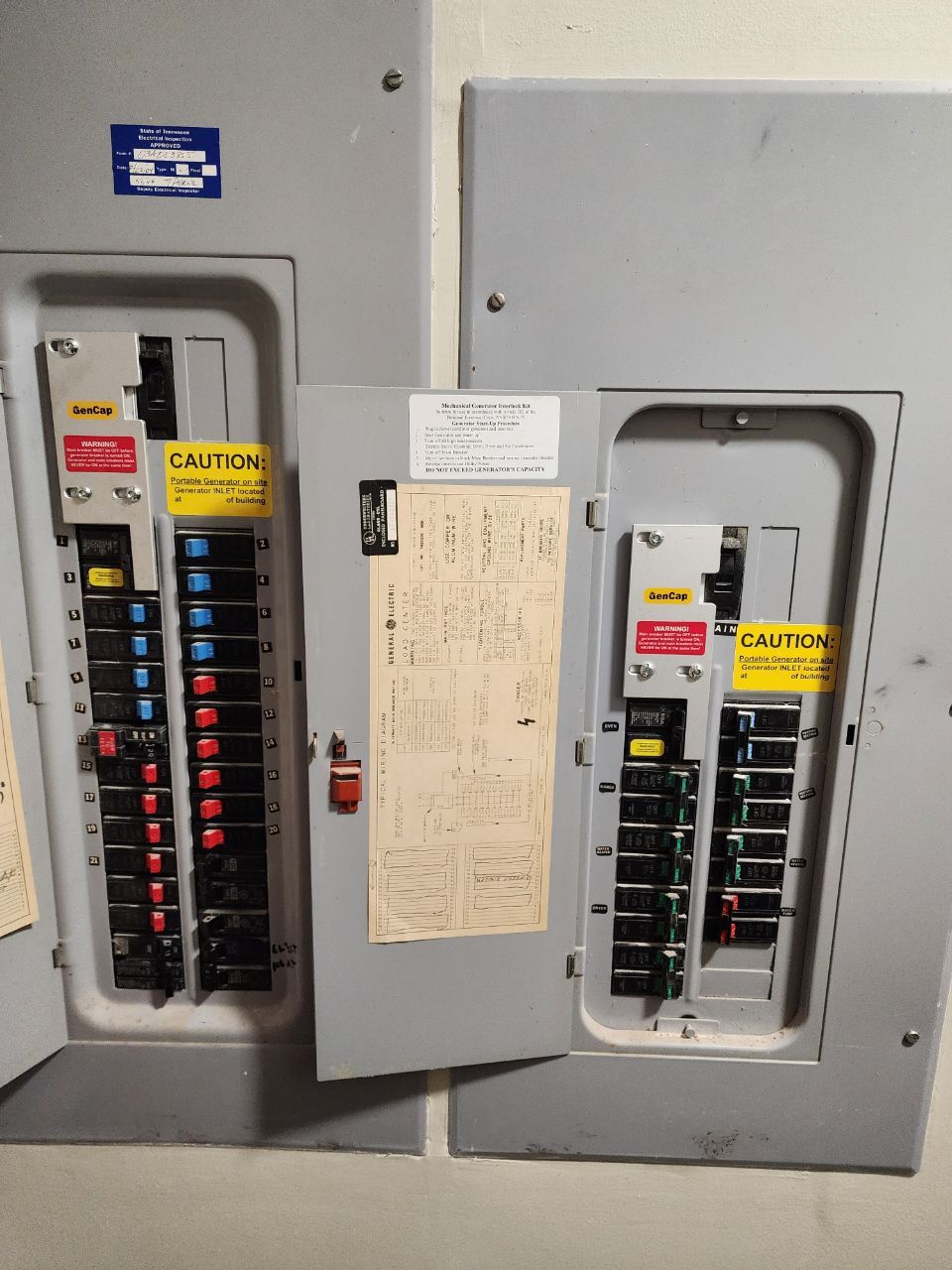 Man in blue jumpsuit and gloves operating machinery control panel.