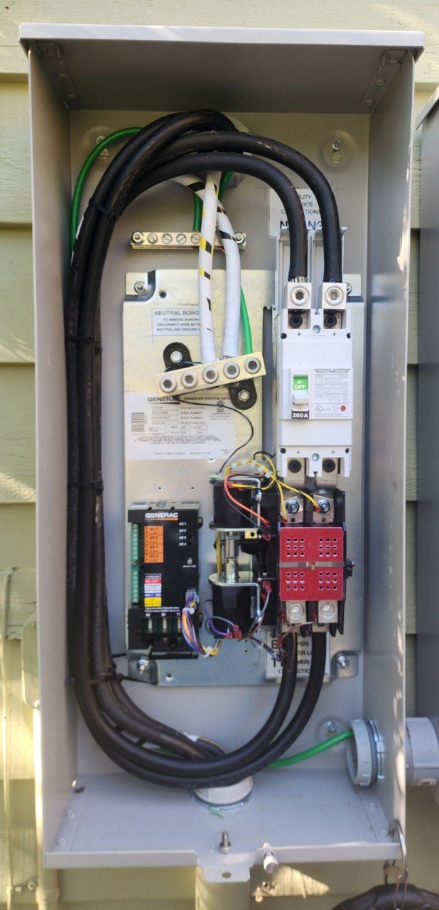 Electrical panel with black wires, green ground wires, and various components.