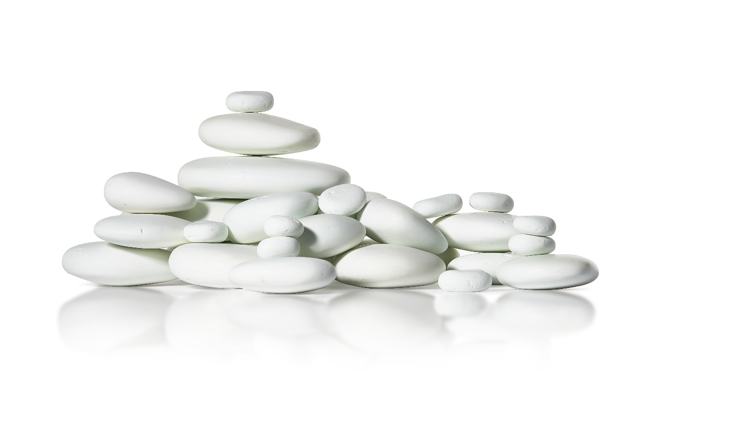 Stacked white smooth stones on a white background