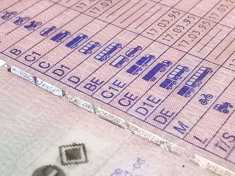 Primo piano di una tabella di misurazione stampata con etichette e segni blu su una superficie beige.