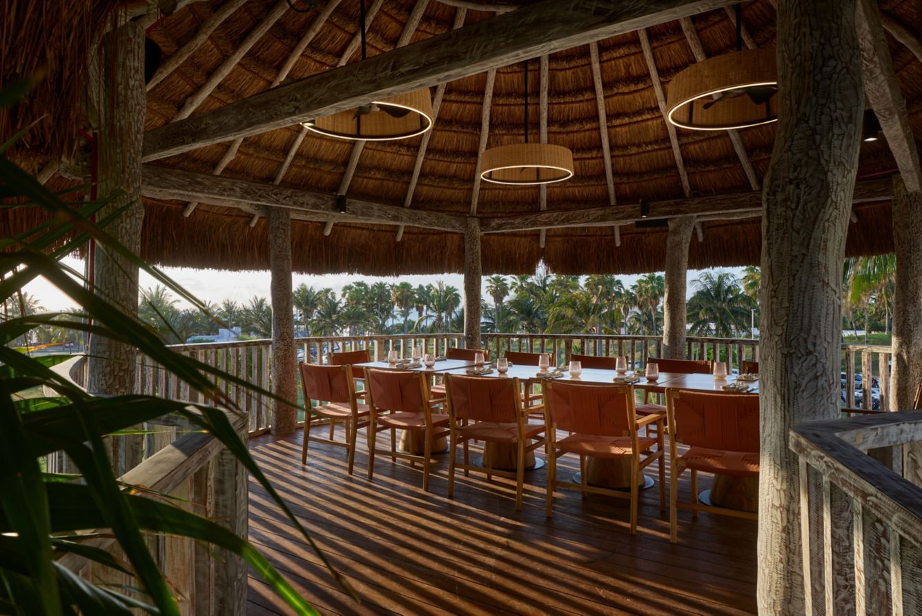 Buffet with food displays in a grand hall, with high windows overlooking water.