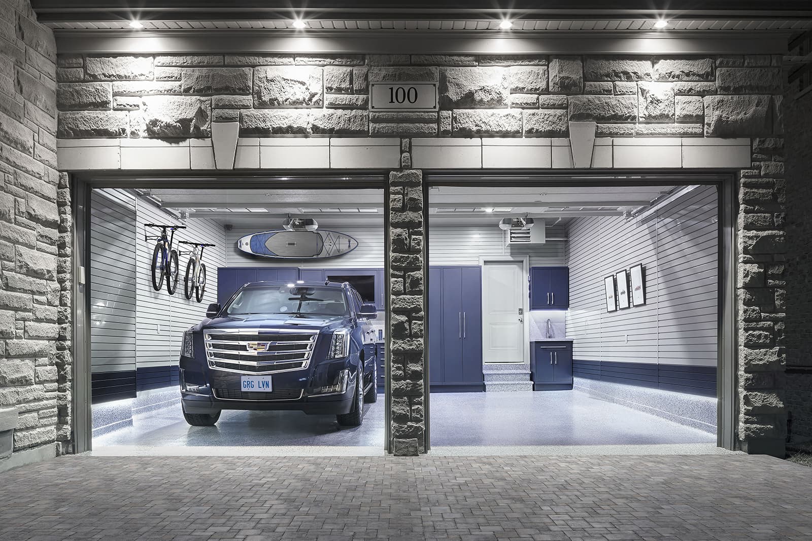 A garage with a car parked inside. The garage is modern, with grey walls and blue accents.