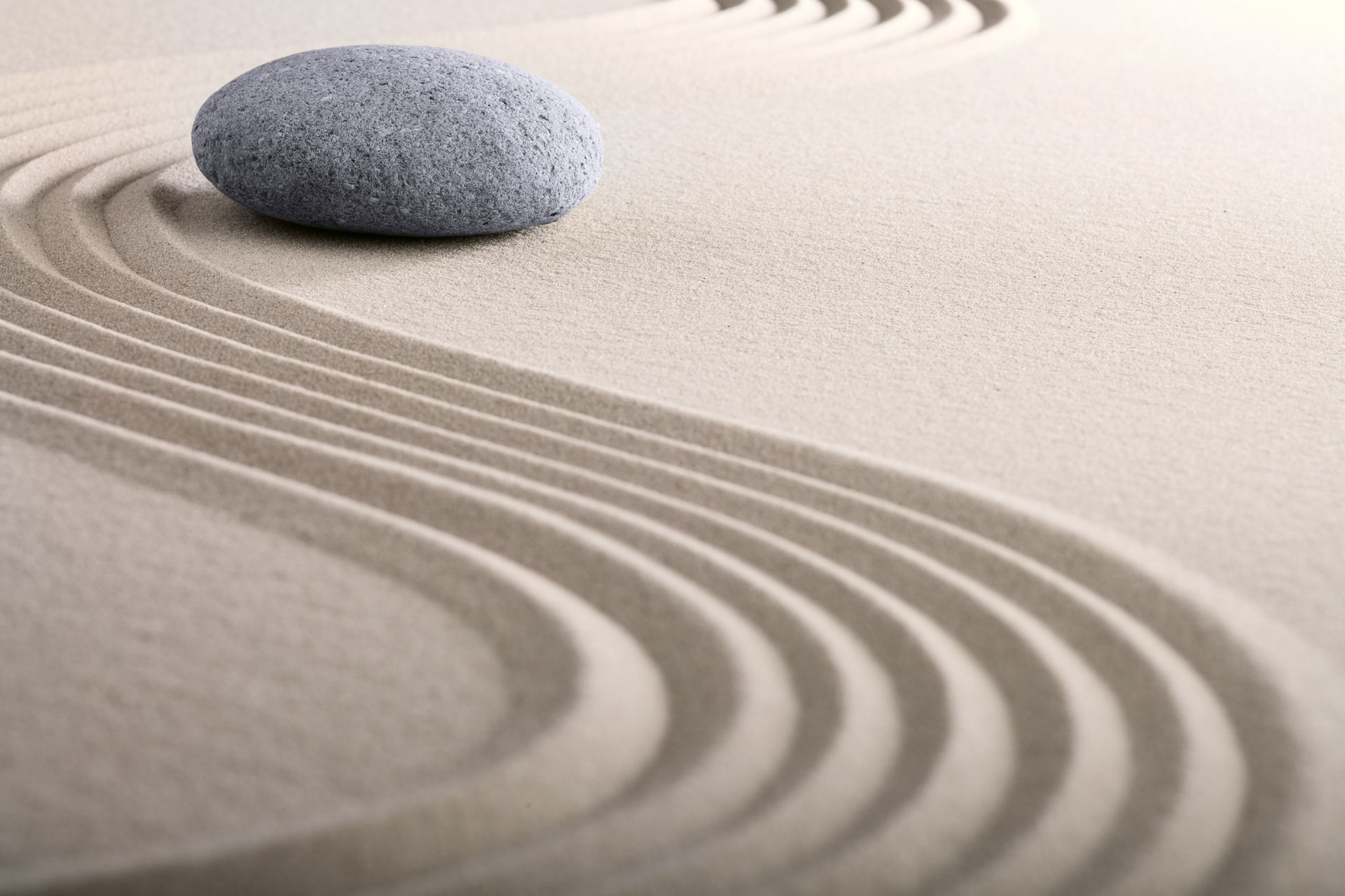 A large rock is sitting on top of a sandy surface.
