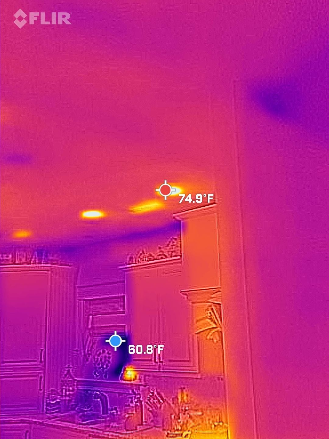Thermal image of a room ceiling and doorway, with temperature readings highlighting warm spots.