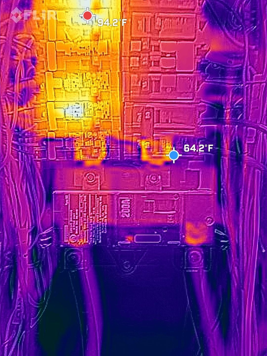 Thermal view of a circuit board with bright yellow heat spots and purple cooler areas.