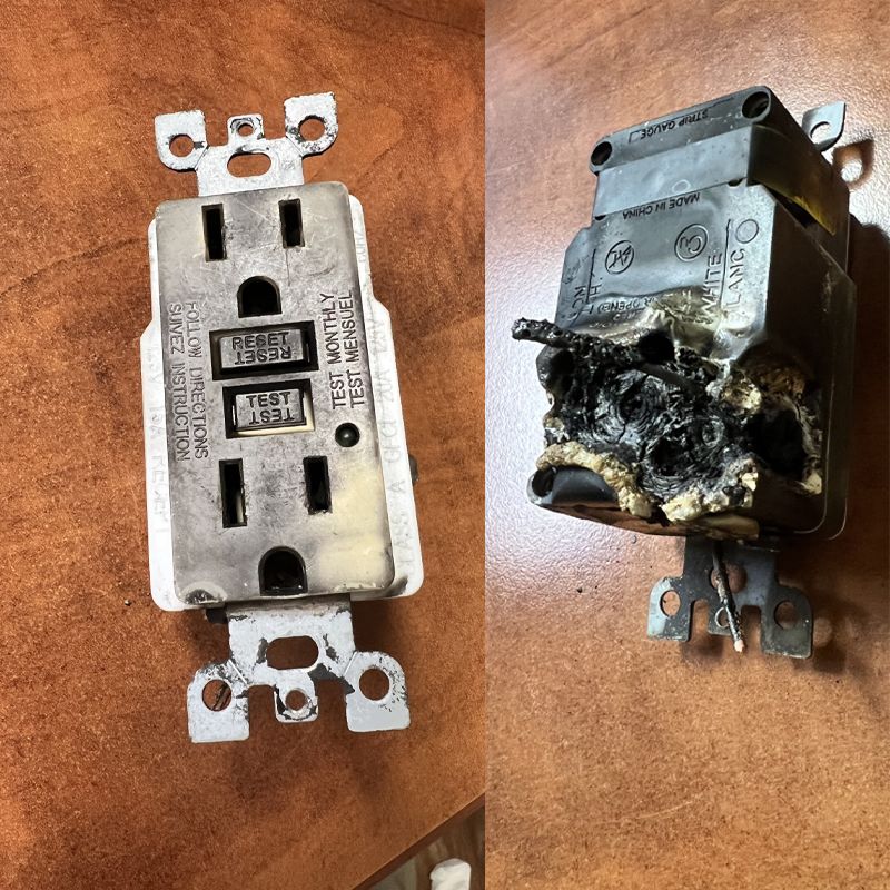 Two outlets side by side: one intact white receptacle and one badly burned, melted outlet on wood surface