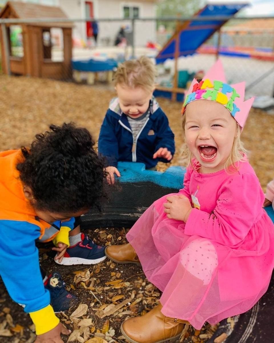 A group of children are playing in the dirt in a playground.