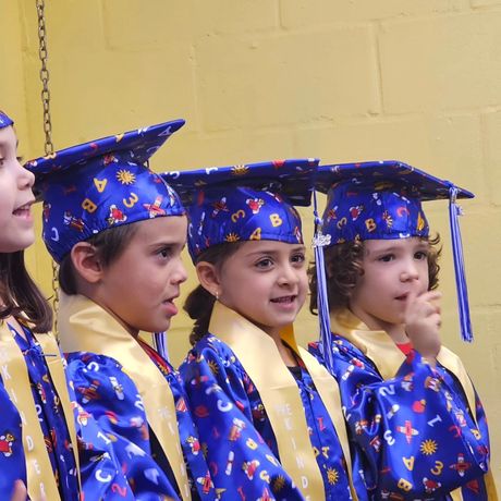 A group of young children wearing graduation caps and gowns