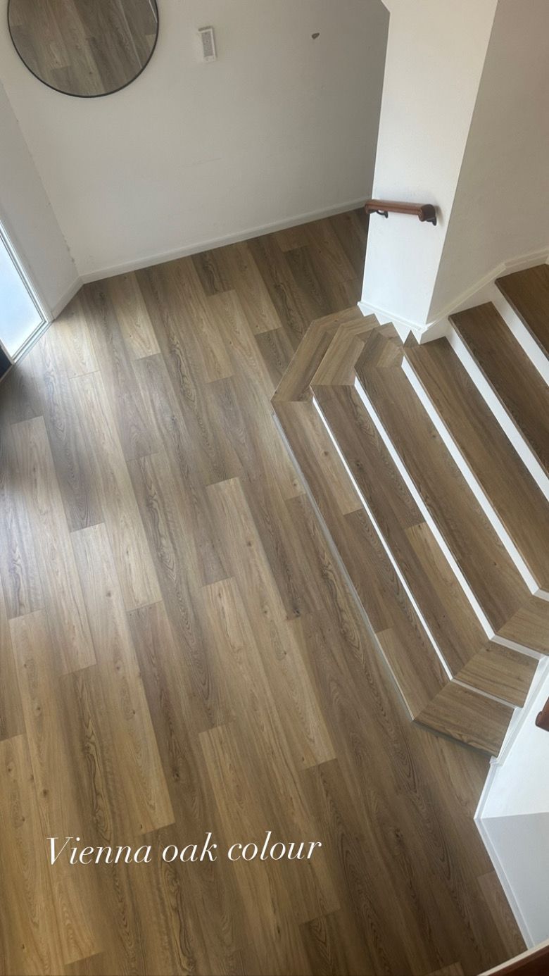 A view of a wooden floor and stairs from above.