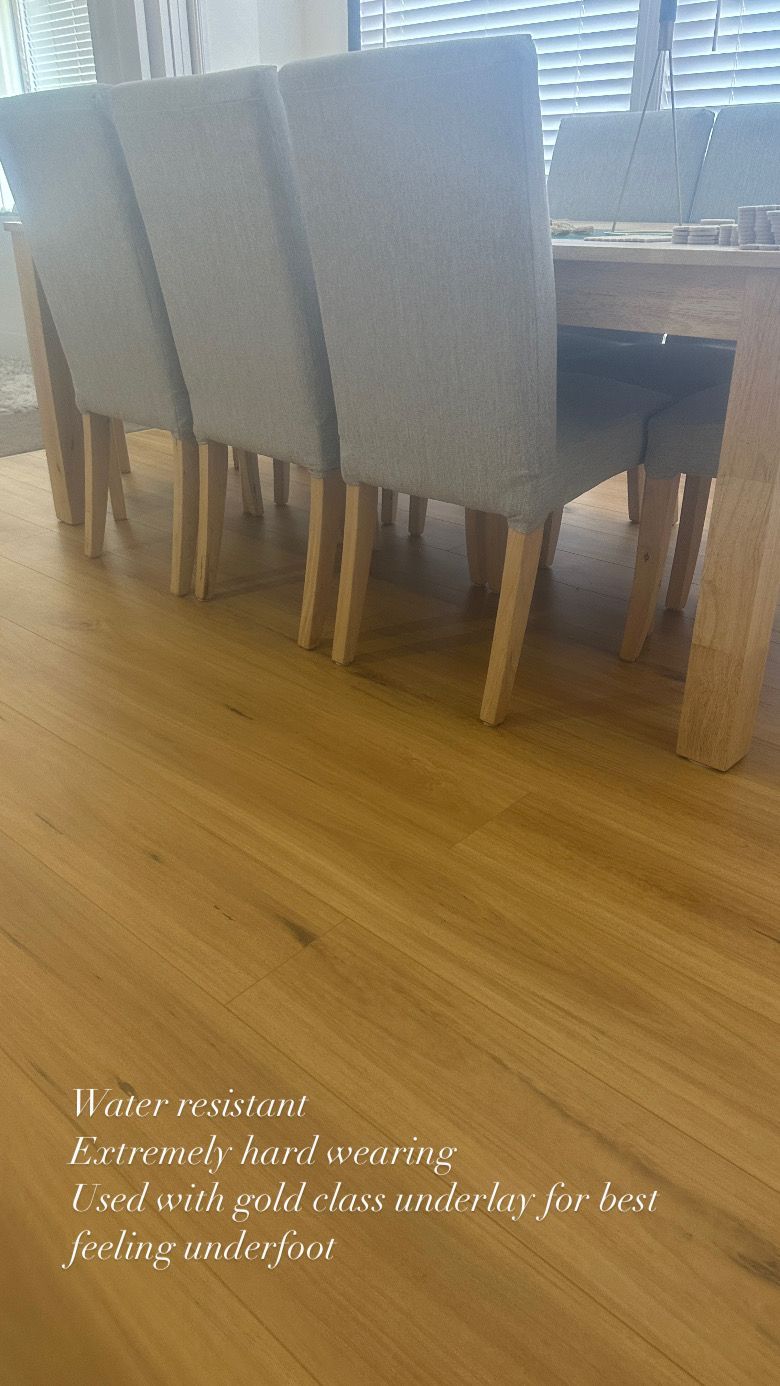 A dining room table and chairs are sitting on a wooden floor.
