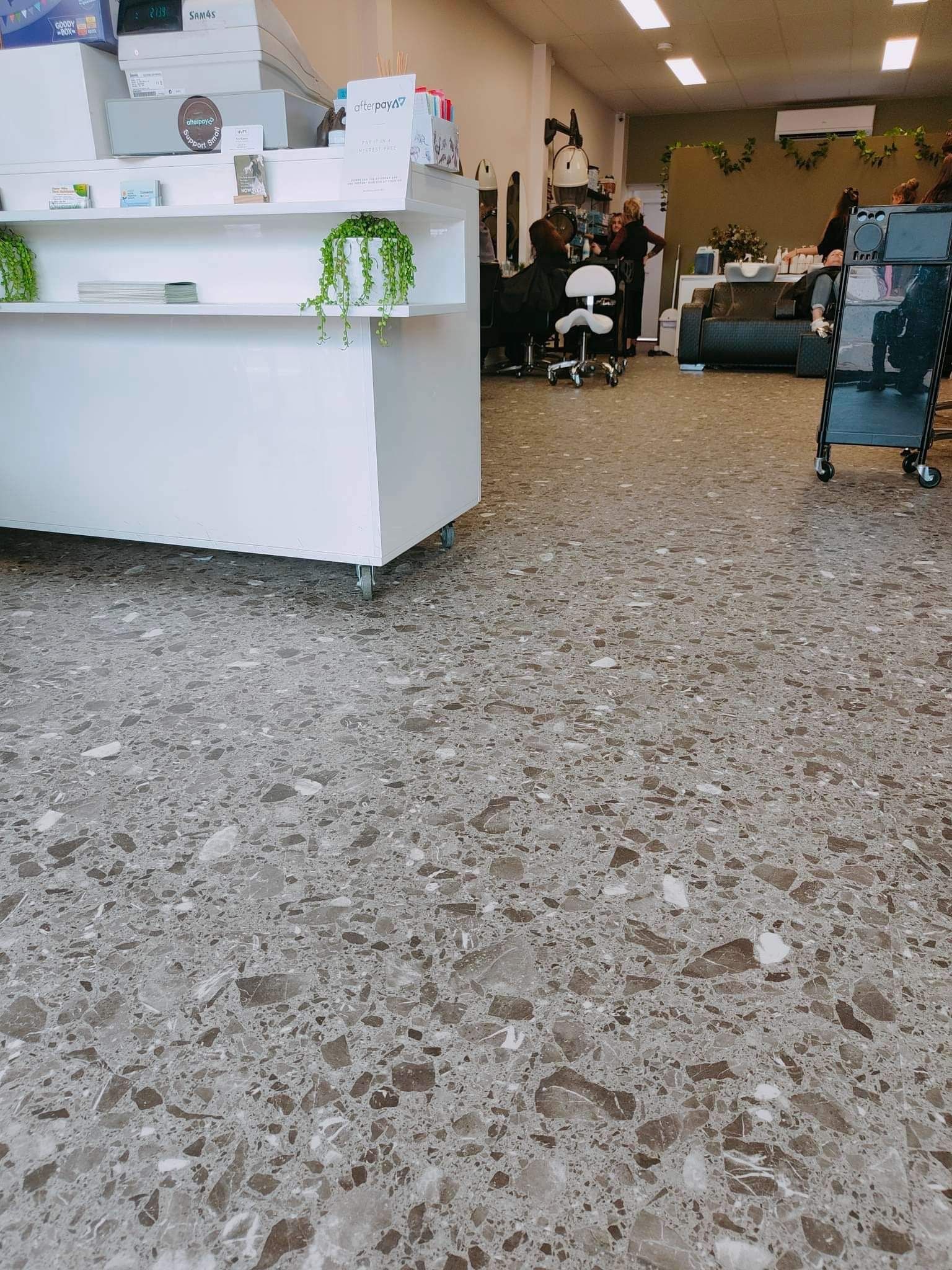 A large room with a marble floor and a white counter.
