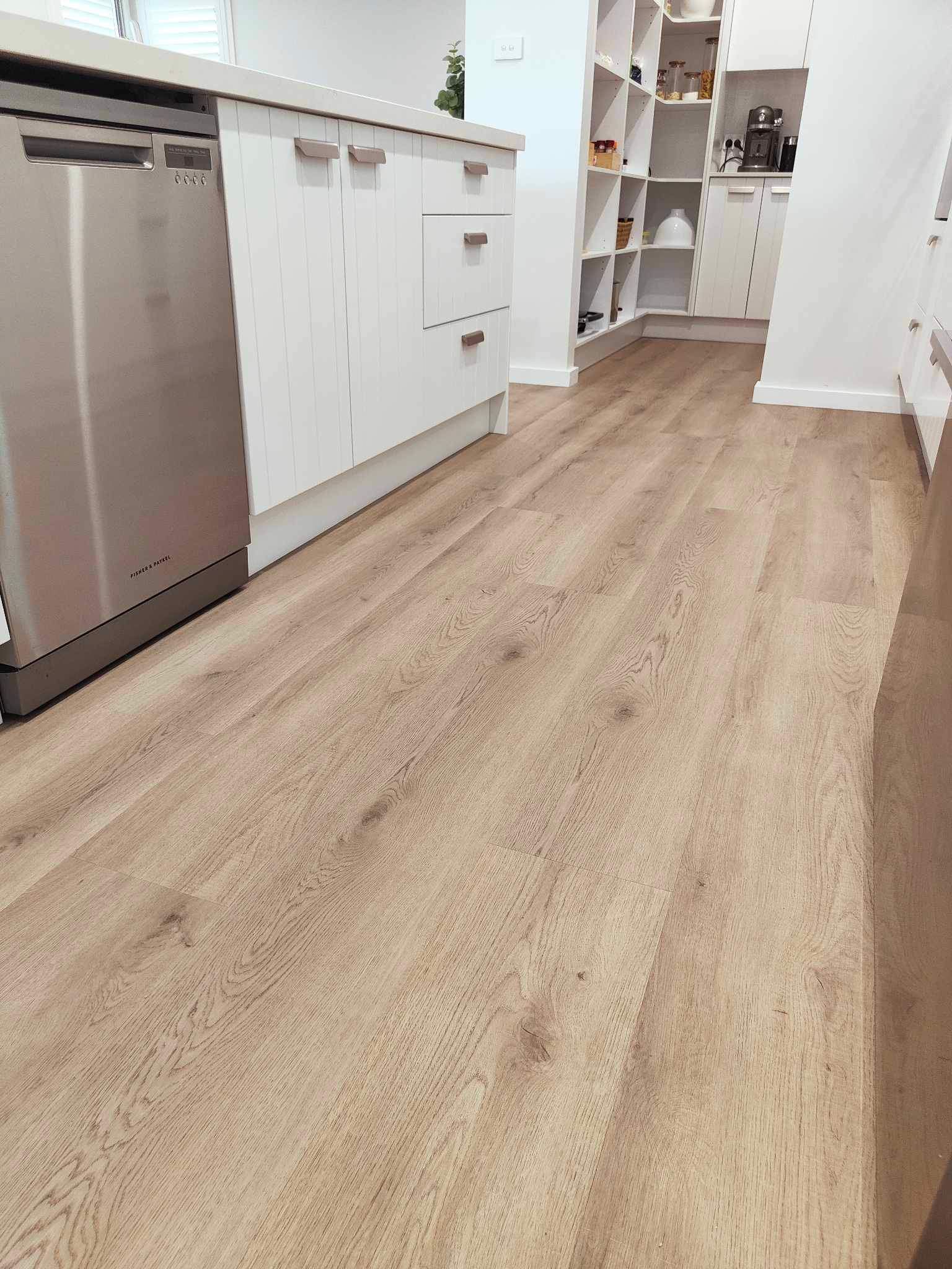 A kitchen with a wooden floor and stainless steel appliances.