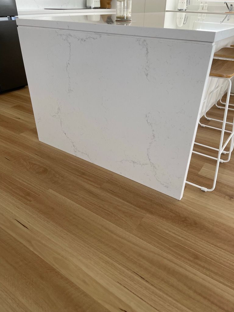 A kitchen with a wooden floor and a white counter top.