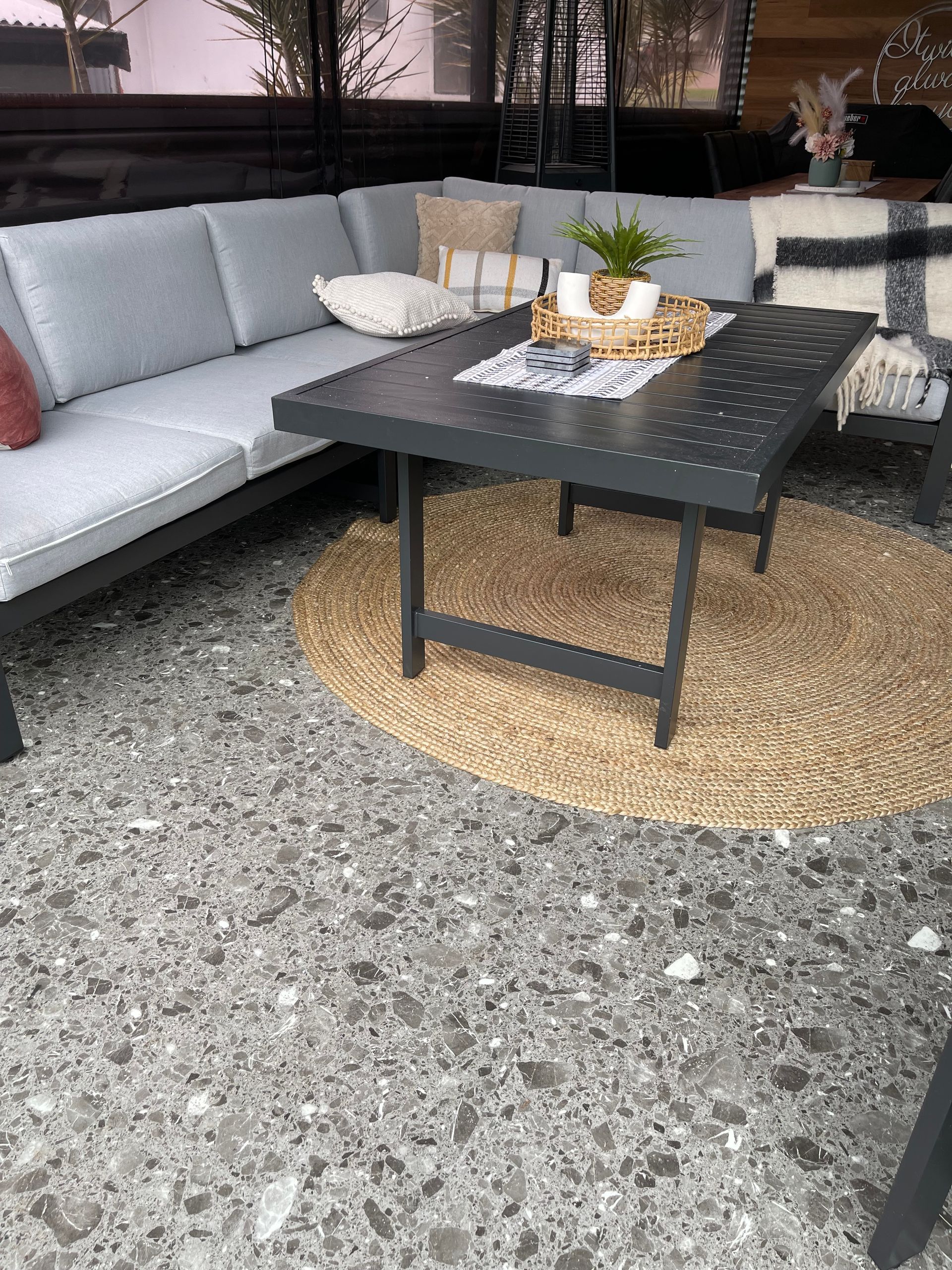 A patio with a couch , chairs , and a coffee table.