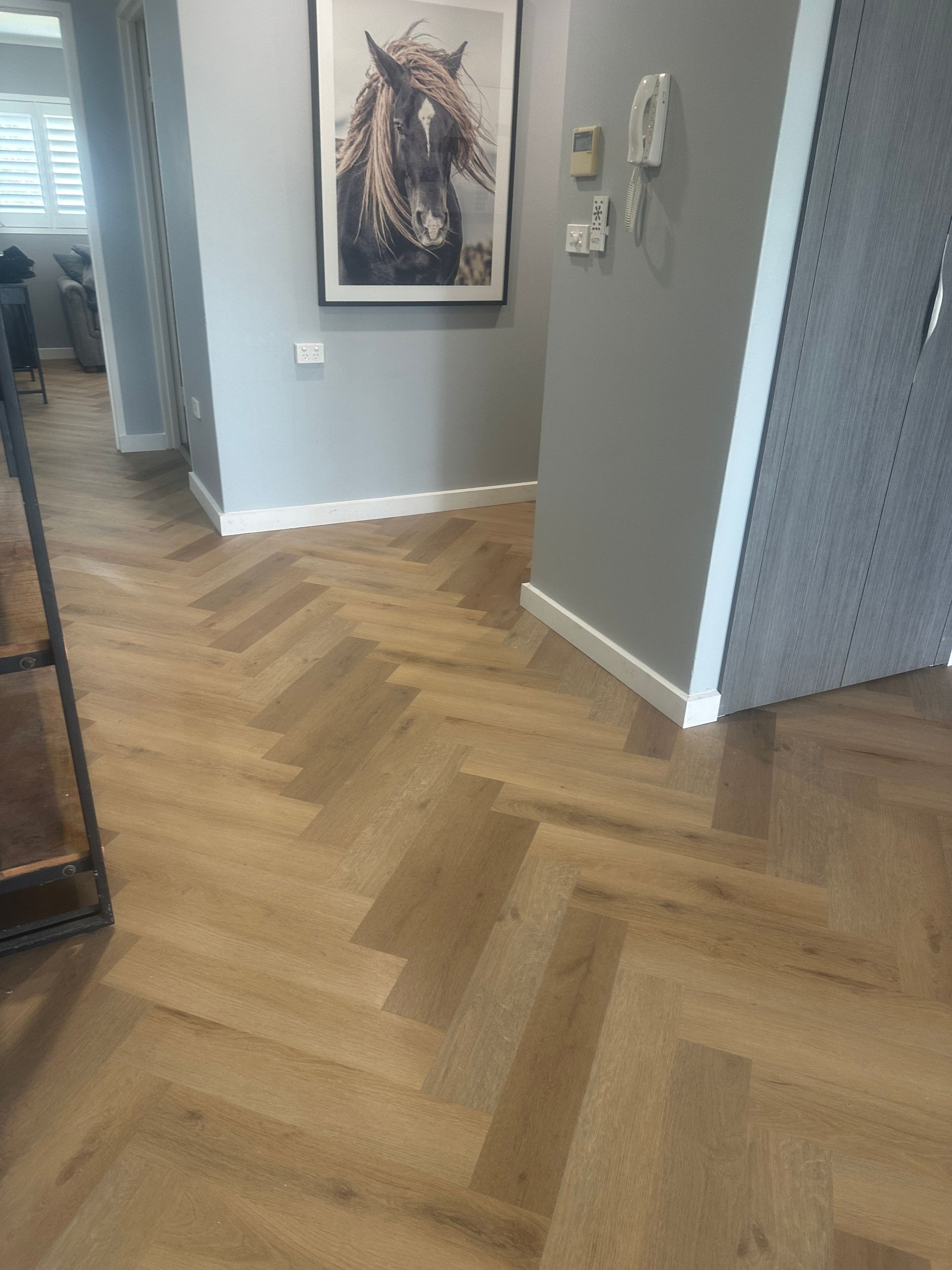 There is a picture of a horse on the wall above the wooden floor.