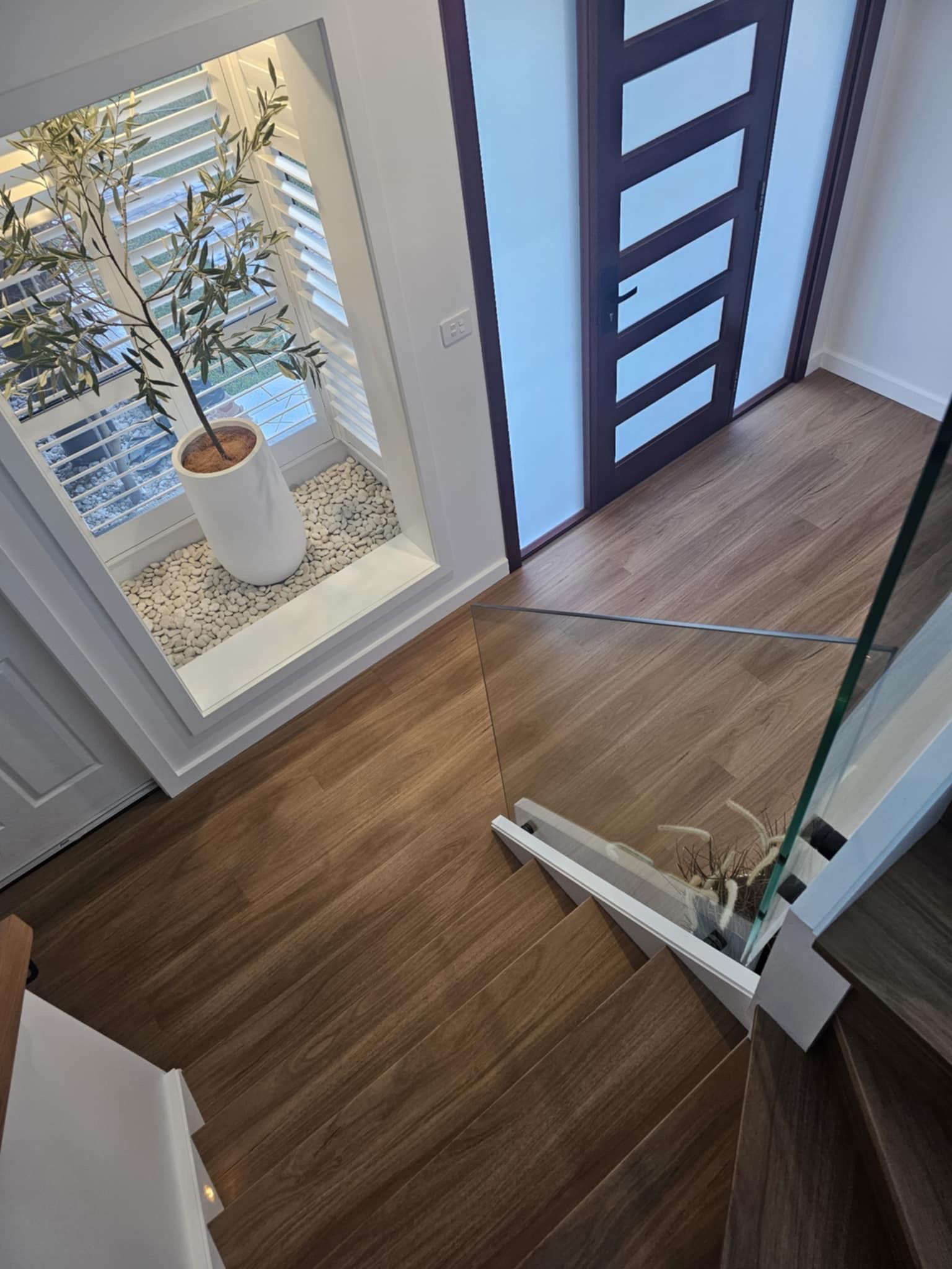 A view of a hallway from the top of a staircase.