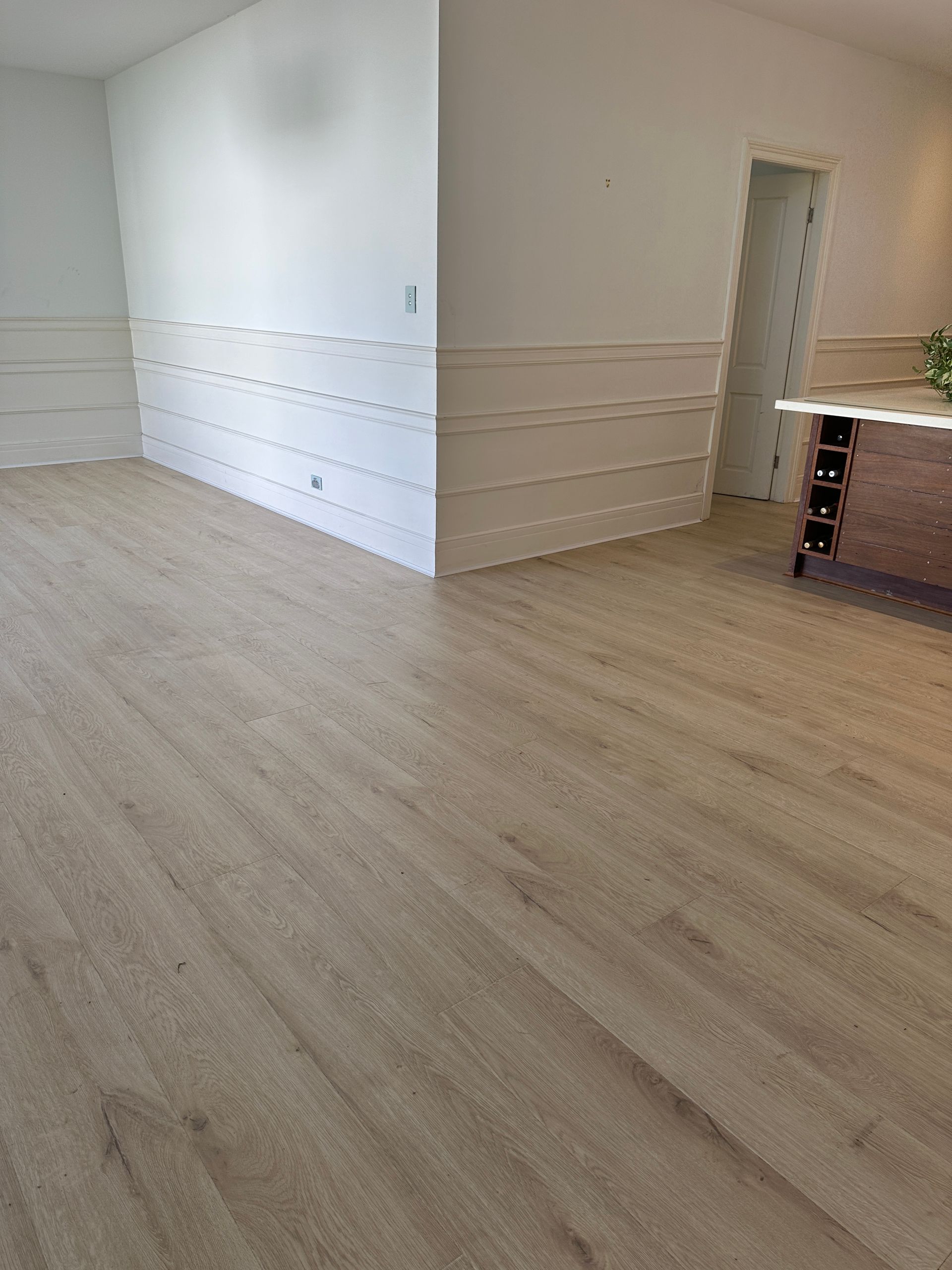 A living room with hardwood floors and white walls.