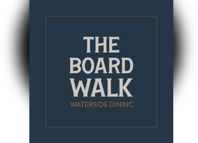 The Board Walk restaurant logo on a dark blue square with gold border and text, “Waterside Dining”