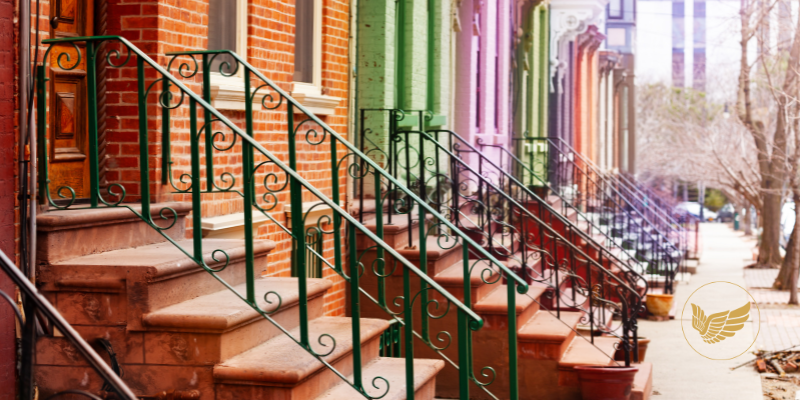 A row of colourful terraced houses with stairs leading up to them.