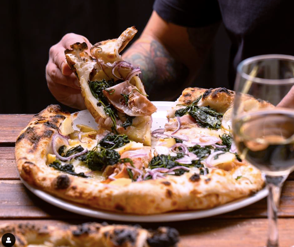 a hand grab pizza at Il Caminetto