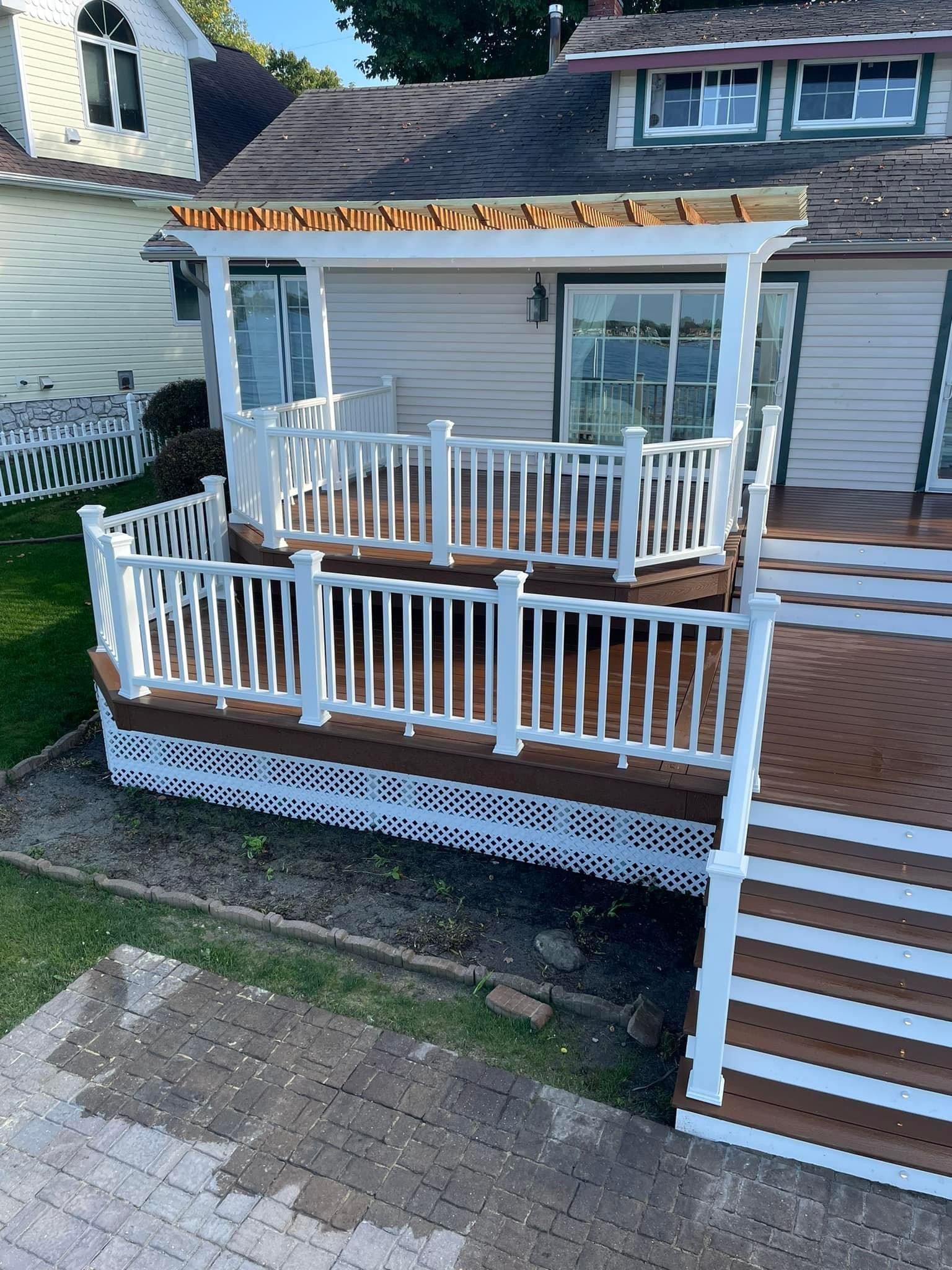 Front porch with white railings, steps, and a covered roof on a house exterior