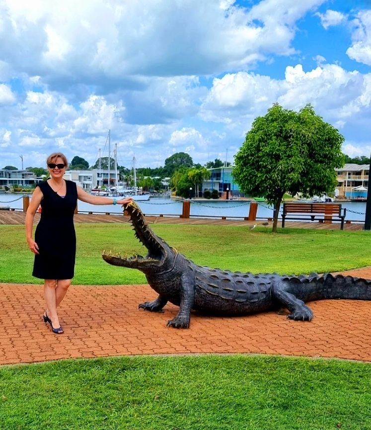 A Woman Is Standing Next To A Statue of a croc — Adding Value CFO Pty Ltd in Larrakeyah, NT