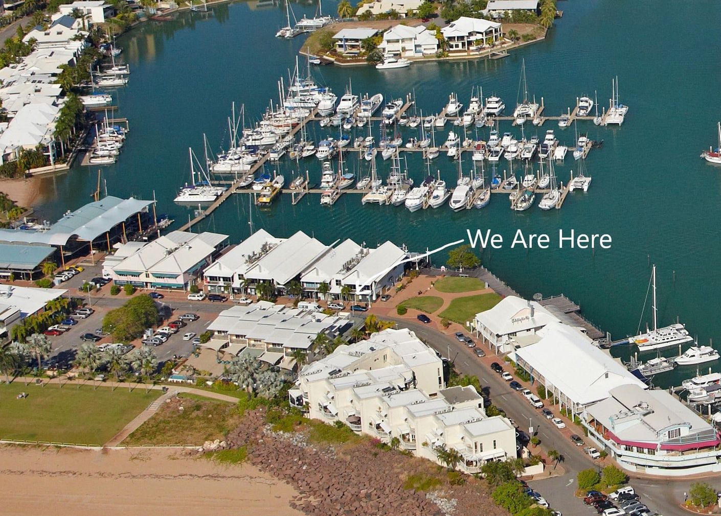 An aerial view of a marina with a sign that says we are here