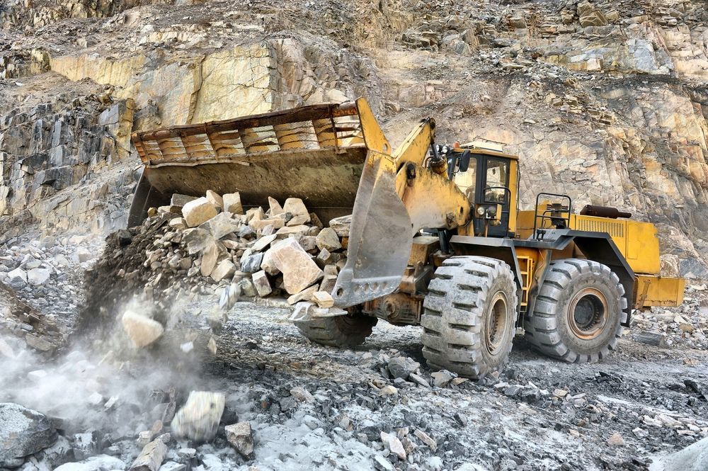 Yellow front loader moving rocks in a quarry against a rocky cliff — Enterprise Air That's Cool In Svensson Heights, QLD