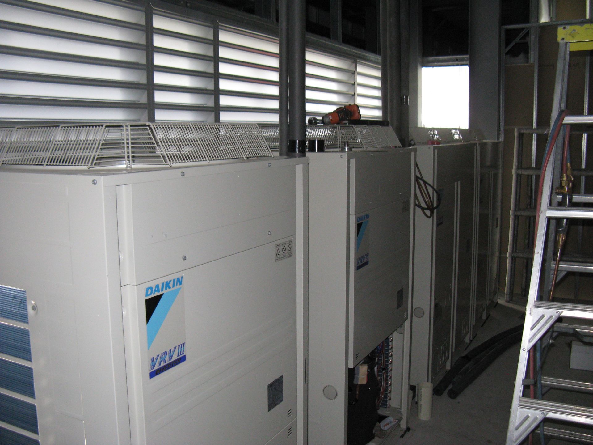 Industrial Equipment Room With Large White Machines, Vents, and a Ladder — Enterprise Air That's Cool In Svensson Heights, QLD