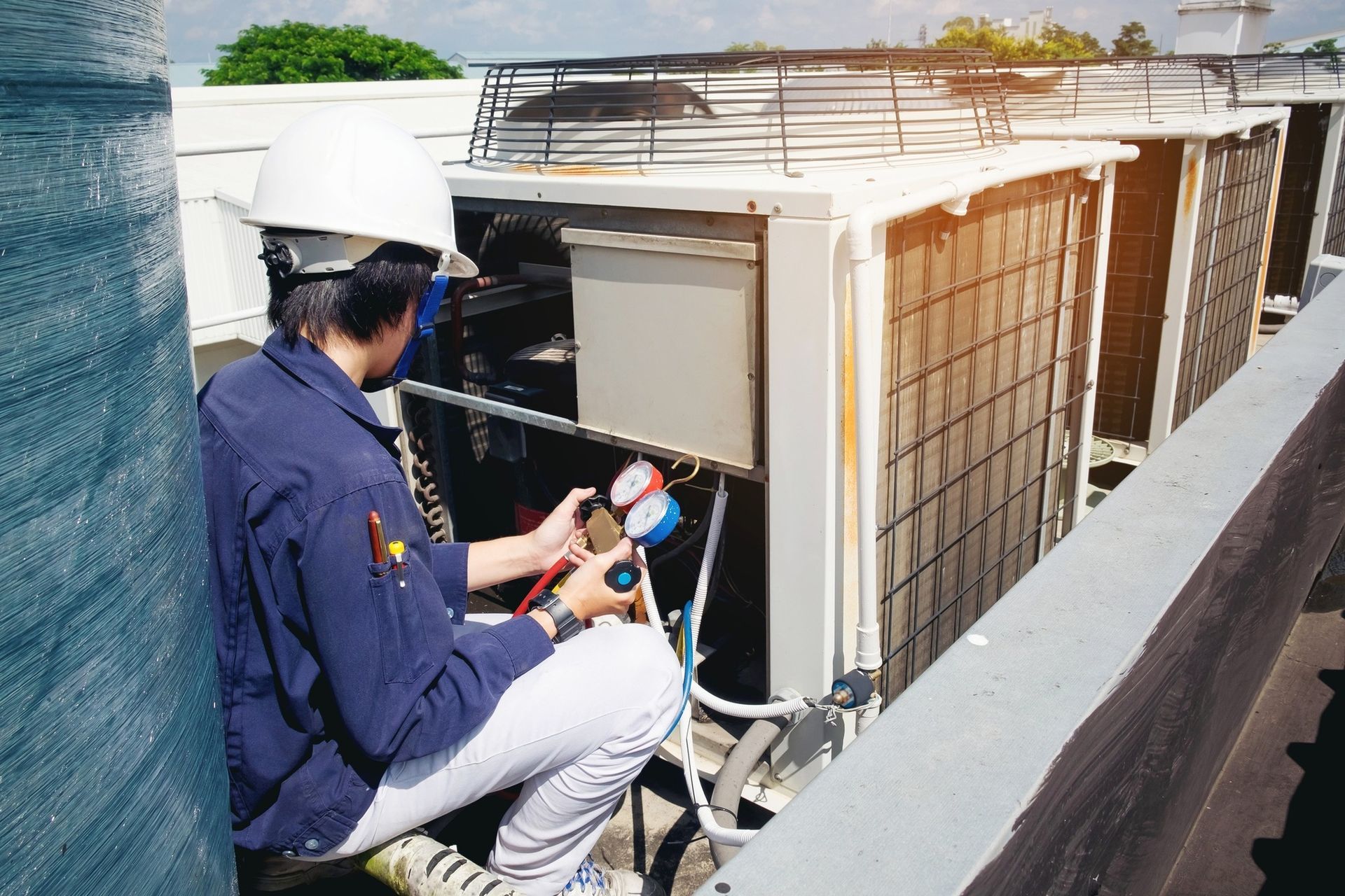 Technician in Red Uniform Servicing Outdoor Air-conditioning Units — Enterprise Air That's Cool In Svensson Heights, QLD
