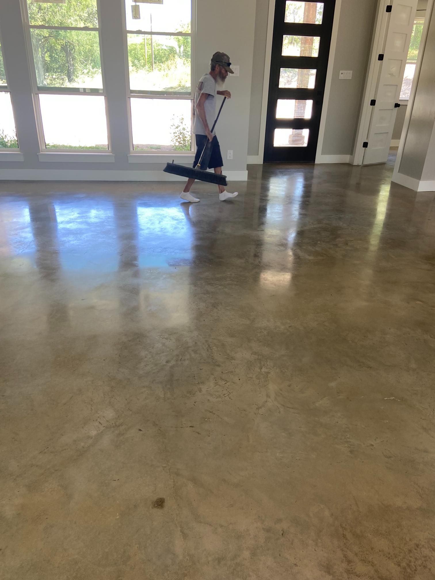 Person standing on a scooter in a bright room with large windows and polished concrete floor